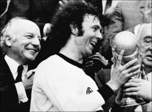 Kapitän Franz Beckenbauer erhält WM-Pokal nach dem 2:1 Sieg gegen Holland am 07. Juli 1974 . Deutschlands damaliger Budnespräsident Walter Scheel (L) applaudiert. (Foto AFP)